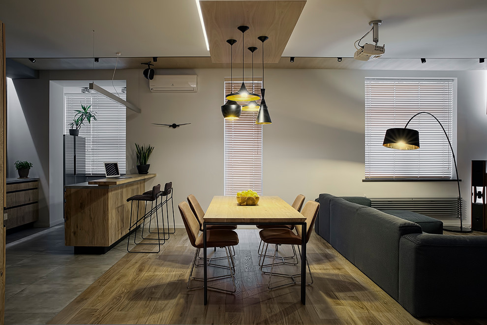 Источник вдохновения для домашнего уюта: столовая в современном стиле с серыми стенами и паркетным полом среднего тона