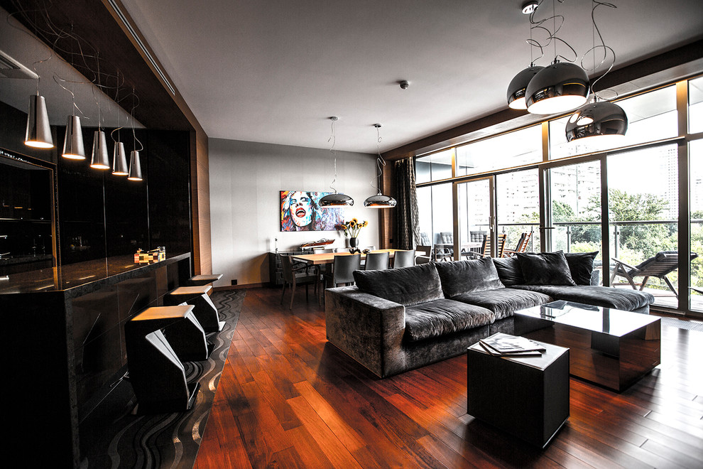 Foto de salón para visitas abierto contemporáneo con paredes grises, suelo de madera en tonos medios y suelo marrón
