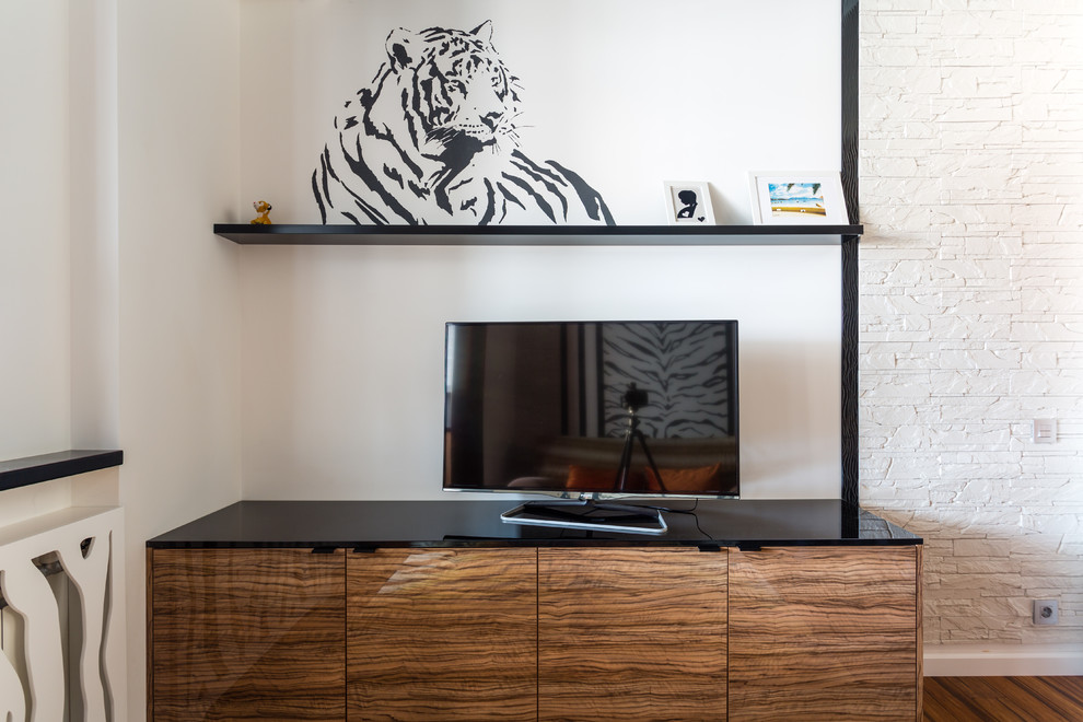 Imagen de salón contemporáneo de tamaño medio sin chimenea con paredes blancas, suelo de bambú, televisor independiente y suelo marrón