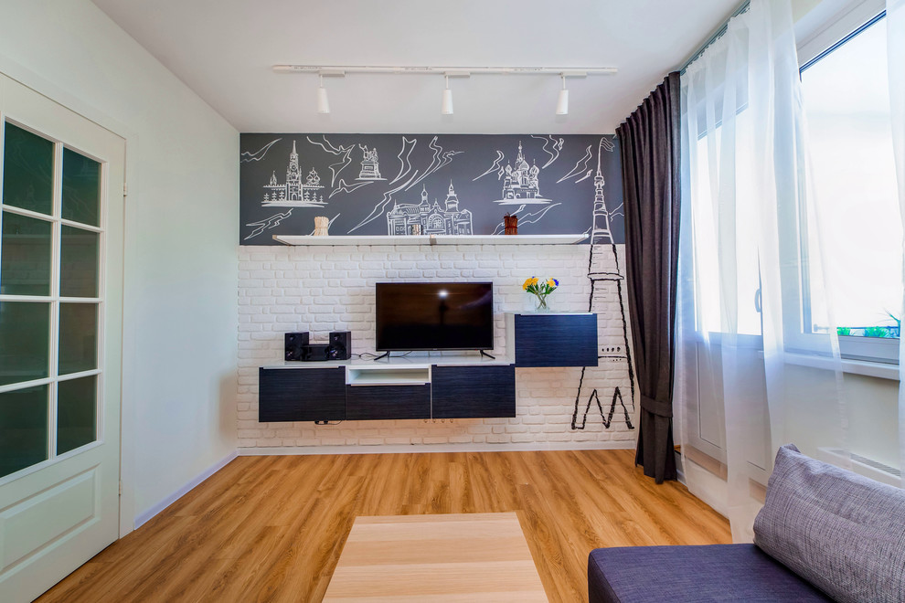 Пример оригинального дизайна: гостиная комната в скандинавском стиле с белыми стенами, отдельно стоящим телевизором и полом из ламината