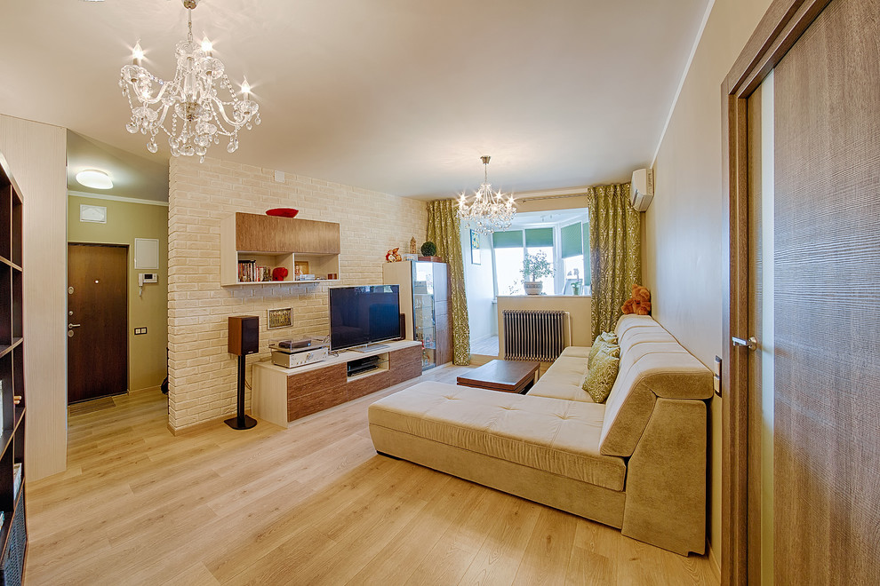 Стильный дизайн: двухуровневая гостиная комната среднего размера в современном стиле с бежевыми стенами, полом из ламината и отдельно стоящим телевизором без камина - последний тренд