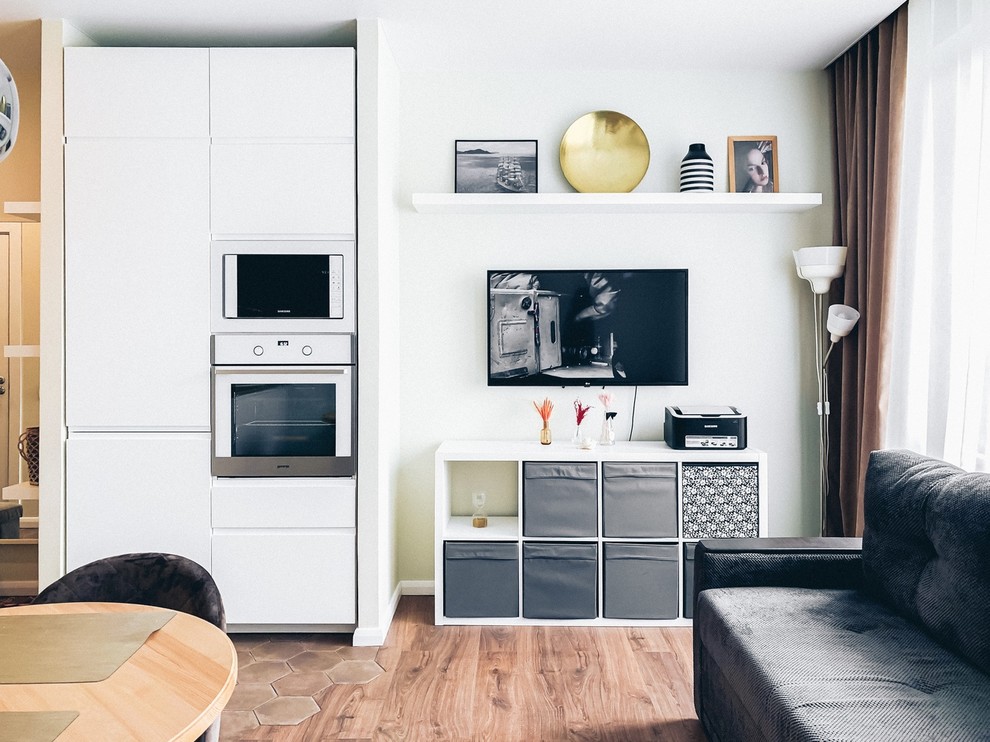 Foto di un piccolo soggiorno nordico con pavimento in laminato, TV a parete e pavimento marrone