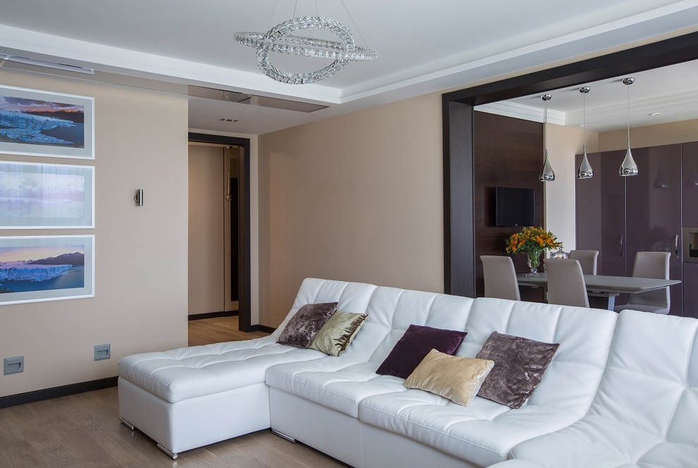 Immagine di un soggiorno minimal con pareti beige e parquet chiaro