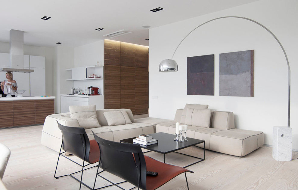 Réalisation d'un grand salon design ouvert avec un mur blanc, un sol beige et parquet clair.
