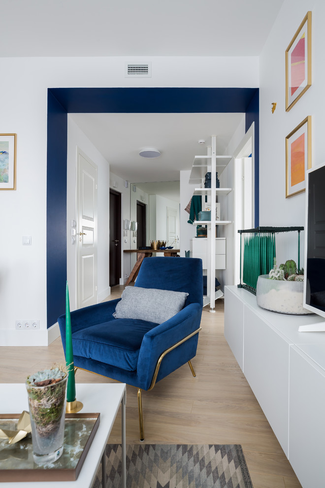 На фото: открытая гостиная комната среднего размера в скандинавском стиле с белыми стенами, светлым паркетным полом и отдельно стоящим телевизором без камина с