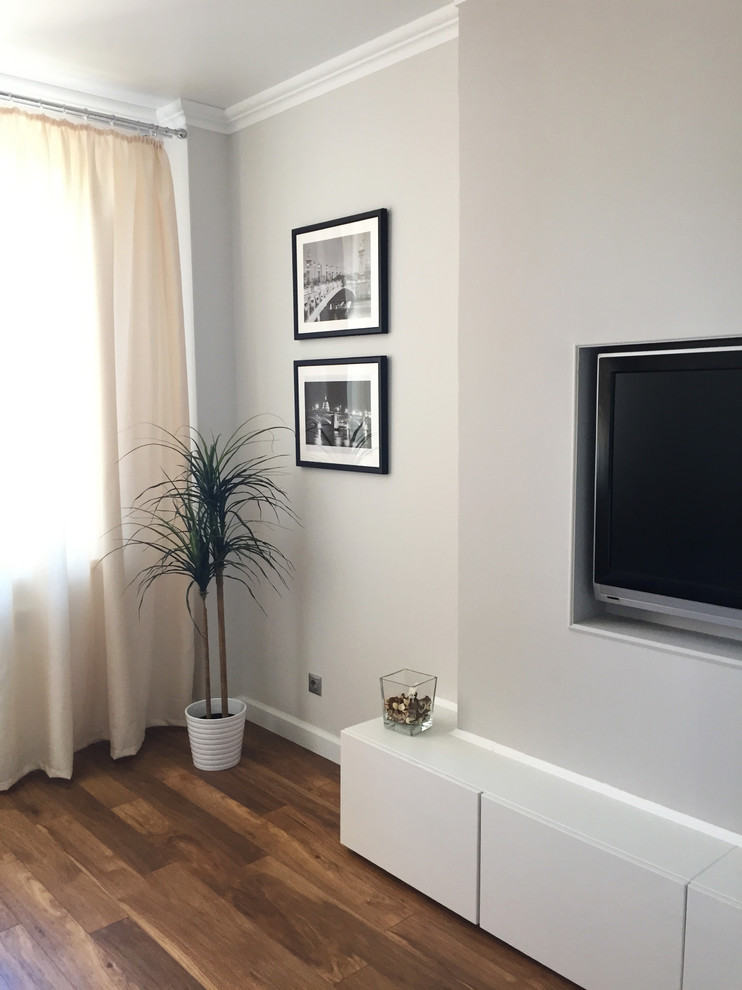 Idee per un soggiorno scandinavo di medie dimensioni e chiuso con pareti grigie, pavimento in laminato, TV a parete e pavimento marrone