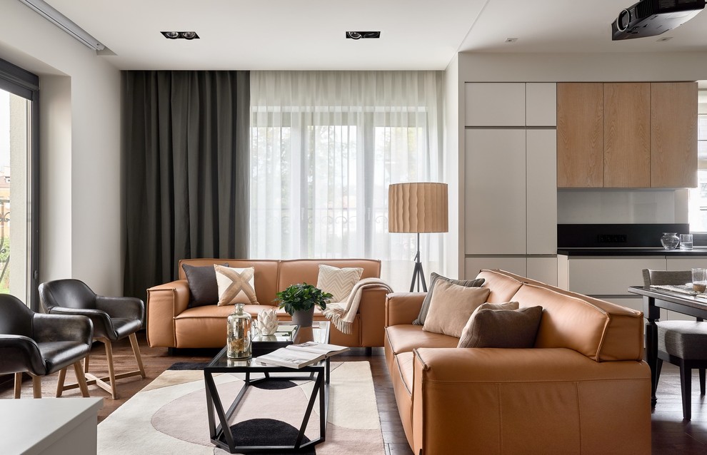 Idée de décoration pour un salon design ouvert avec un mur blanc, un sol en bois brun, un sol marron et éclairage.