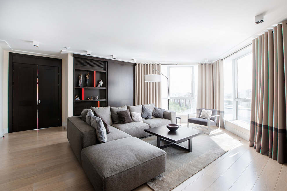 Cette image montre un salon design ouvert avec un sol en bois brun, un sol marron et éclairage.