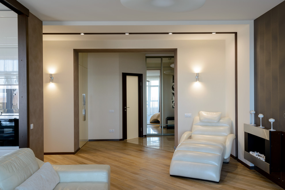 На фото: большая открытая, объединенная гостиная комната в современном стиле с коричневыми стенами, полом из ламината, подвесным камином, фасадом камина из металла и отдельно стоящим телевизором