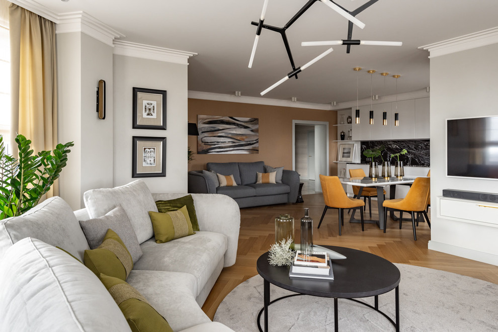 Стильный дизайн: открытая гостиная комната среднего размера в современном стиле с с книжными шкафами и полками, серыми стенами, телевизором на стене, желтым полом и паркетным полом среднего тона - последний тренд