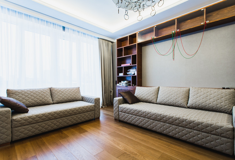 Immagine di un soggiorno design di medie dimensioni e aperto con pareti grigie e pavimento in legno massello medio