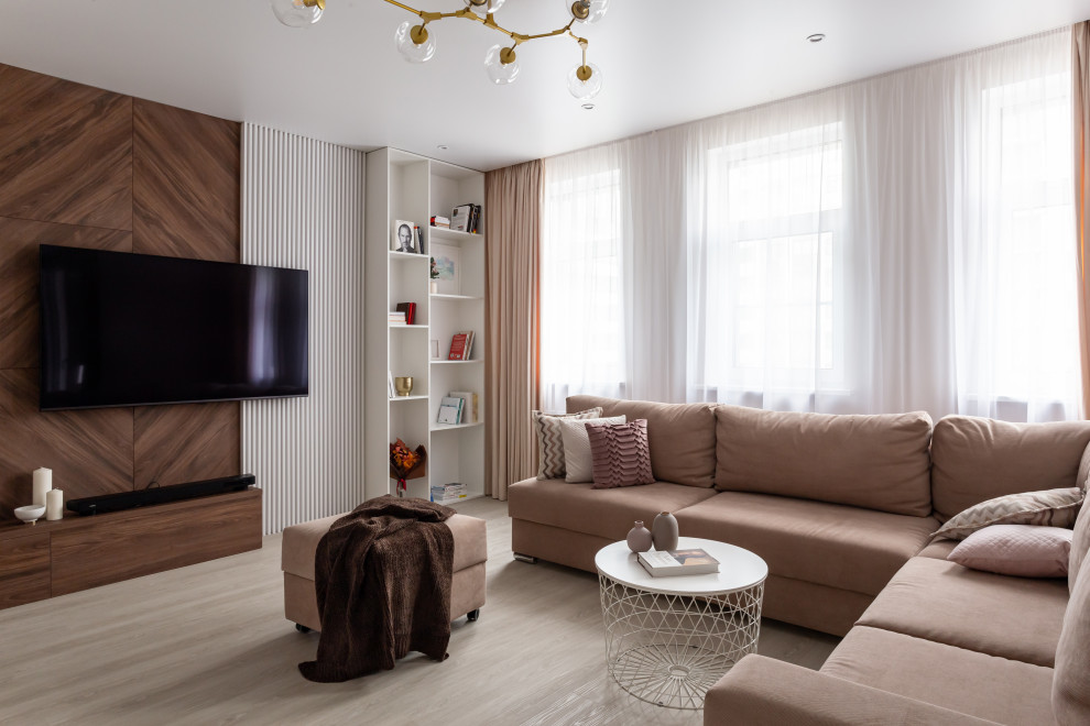 Modelo de salón para visitas actual con suelo de madera clara, televisor colgado en la pared y suelo beige
