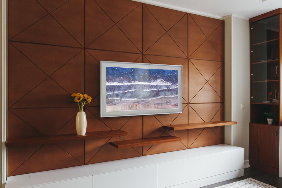 Стильный дизайн: гостиная комната в современном стиле с телевизором на стене и тюлем на окнах - последний тренд