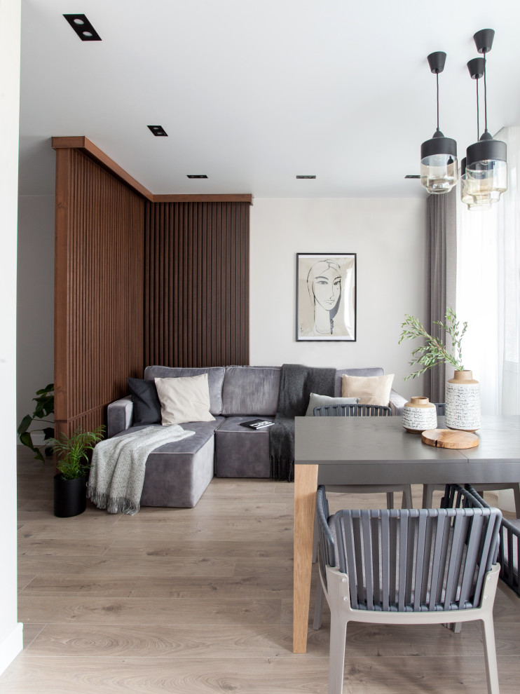 Inspiration pour un salon design ouvert avec un mur gris, parquet clair et un sol beige.