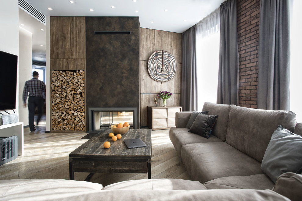 Diseño de sala de estar contemporánea con paredes marrones, chimenea de doble cara, televisor colgado en la pared, suelo de madera clara y suelo beige