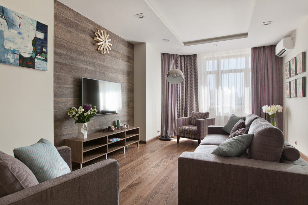Источник вдохновения для домашнего уюта: гостиная комната в современном стиле с белыми стенами, паркетным полом среднего тона, телевизором на стене и коричневым полом