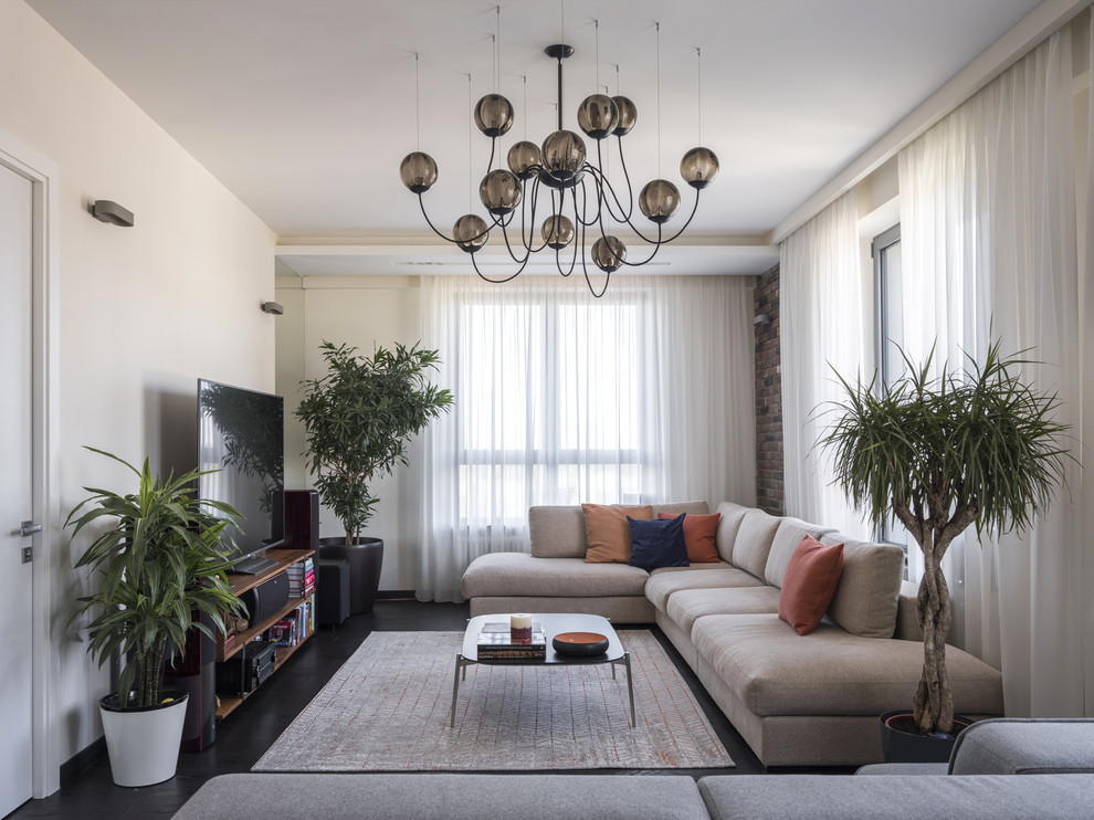 Mittelgroßes, Repräsentatives, Offenes Modernes Wohnzimmer mit beiger Wandfarbe, dunklem Holzboden, freistehendem TV und schwarzem Boden in Moskau