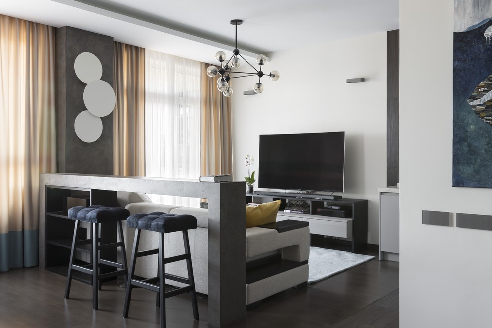 Immagine di un piccolo soggiorno design aperto con pareti beige, parquet scuro e TV autoportante