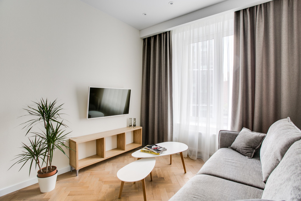 Idee per un soggiorno minimal con pareti bianche, parquet chiaro, TV a parete e pavimento beige