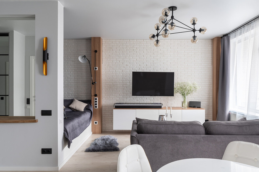 This is an example of a small contemporary open plan living room in Saint Petersburg with white walls, a wall mounted tv, beige floors and feature lighting.