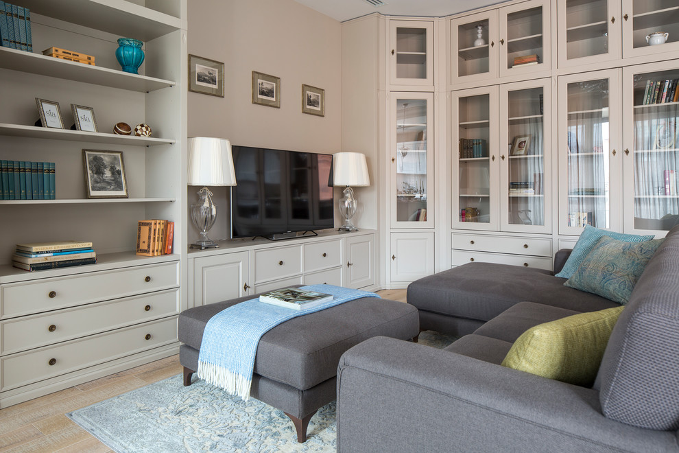 Идея дизайна: открытая гостиная комната в стиле неоклассика (современная классика) с с книжными шкафами и полками, бежевыми стенами, светлым паркетным полом и отдельно стоящим телевизором