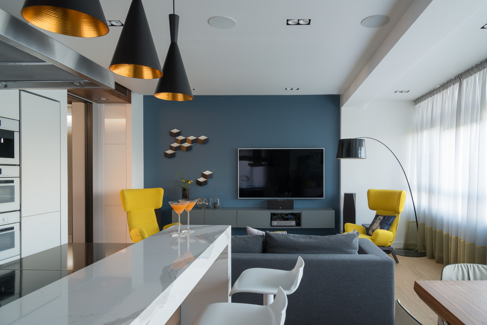 Idéer för ett modernt vardagsrum, med en hemmabar, blå väggar, ljust trägolv och en väggmonterad TV
