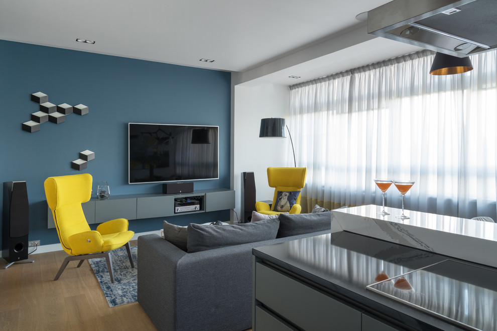 Esempio di un soggiorno aperto con pareti blu e TV a parete
