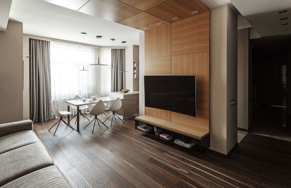 Свежая идея для дизайна: открытая, объединенная гостиная комната в современном стиле с бежевыми стенами, темным паркетным полом, телевизором на стене и коричневым полом - отличное фото интерьера