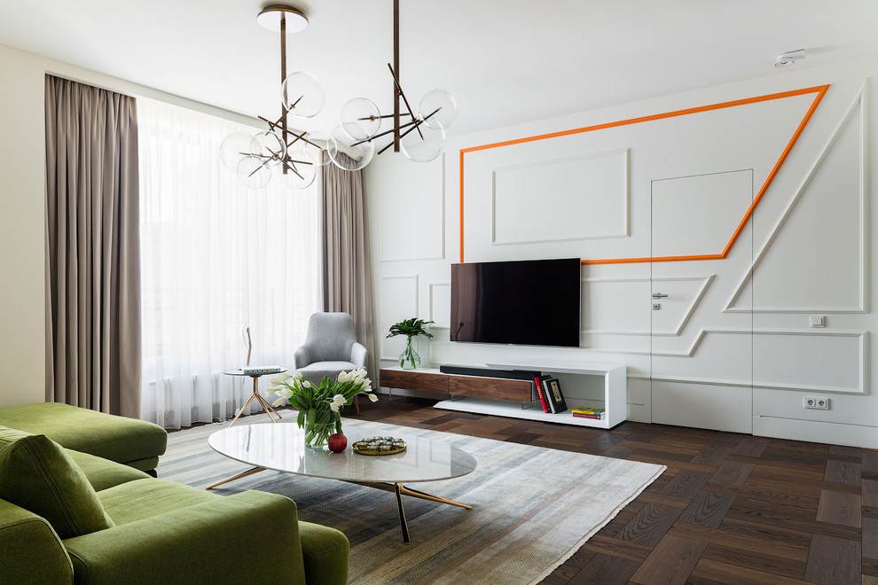Стильный дизайн: большая гостиная комната в современном стиле с белыми стенами, коричневым полом, темным паркетным полом и телевизором на стене - последний тренд