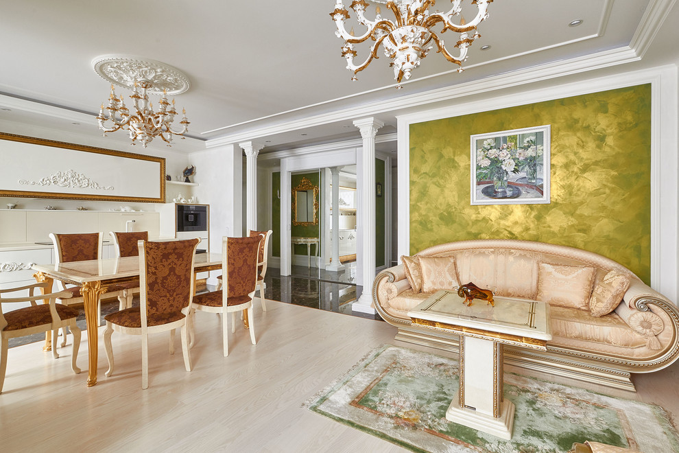 Ejemplo de salón abierto tradicional con paredes verdes, suelo de madera clara, televisor colgado en la pared y suelo beige