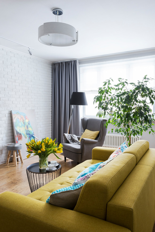 Идея дизайна: изолированная гостиная комната в современном стиле с белыми стенами, паркетным полом среднего тона, телевизором на стене и коричневым полом