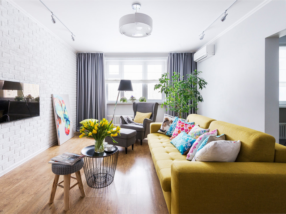 Источник вдохновения для домашнего уюта: изолированная гостиная комната в современном стиле с белыми стенами, паркетным полом среднего тона, телевизором на стене и коричневым полом