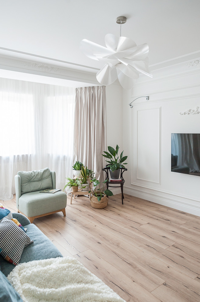 Inspiration för eklektiska vardagsrum, med en väggmonterad TV, vita väggar, ljust trägolv och beiget golv