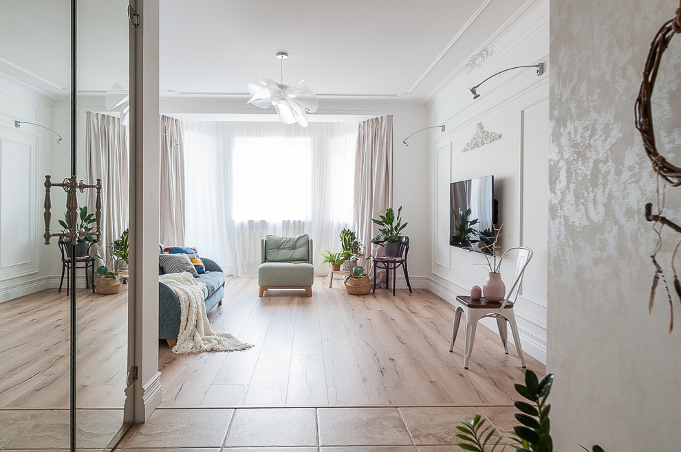 Immagine di un soggiorno bohémian con pareti bianche, parquet chiaro, TV a parete e pavimento beige