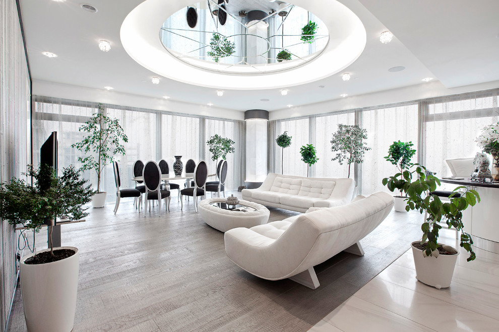Diseño de salón para visitas abierto contemporáneo con paredes blancas, suelo de madera clara, televisor independiente y cortinas