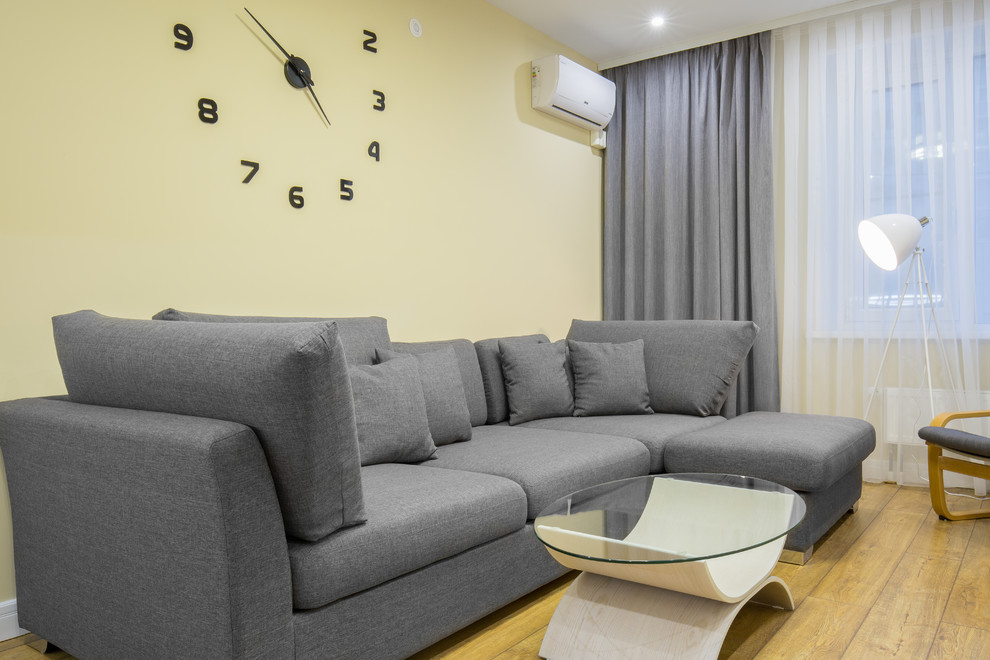 Foto di un soggiorno design di medie dimensioni e stile loft con libreria, pareti beige, pavimento in vinile, TV a parete e pavimento marrone