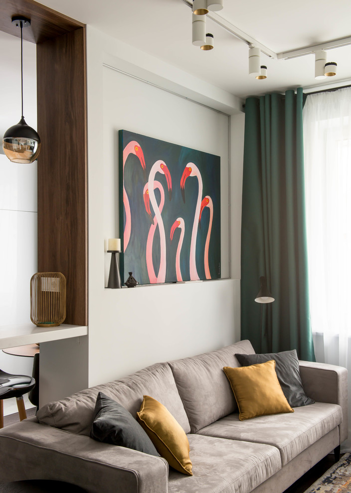 This is an example of a small contemporary open plan living room in Moscow with white walls, dark hardwood flooring, a wall mounted tv and brown floors.