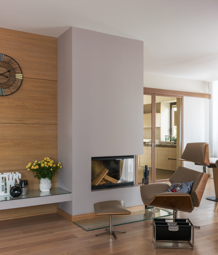 Ispirazione per un soggiorno minimal con pavimento in legno massello medio, camino classico e pavimento marrone