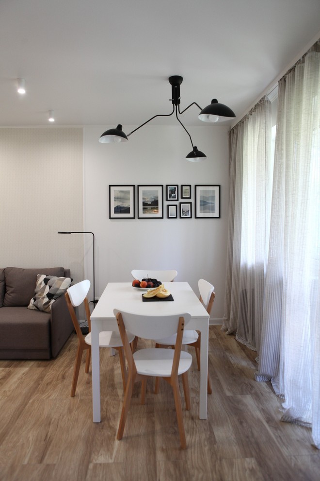 Esempio di un piccolo soggiorno minimal aperto con sala formale, pareti bianche, pavimento in laminato, TV a parete e pavimento beige