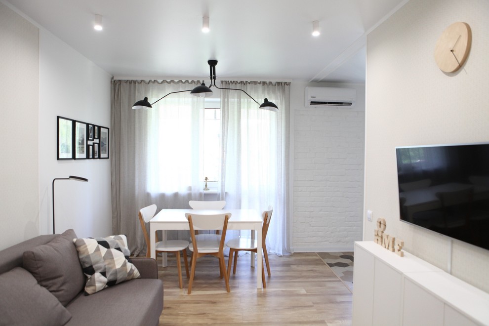 Aménagement d'un petit salon contemporain ouvert avec une salle de réception, un mur blanc, sol en stratifié, un téléviseur fixé au mur et un sol beige.