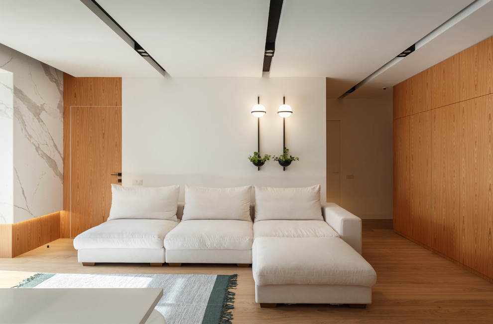 На фото: гостиная комната в современном стиле с белыми стенами, паркетным полом среднего тона и коричневым полом с