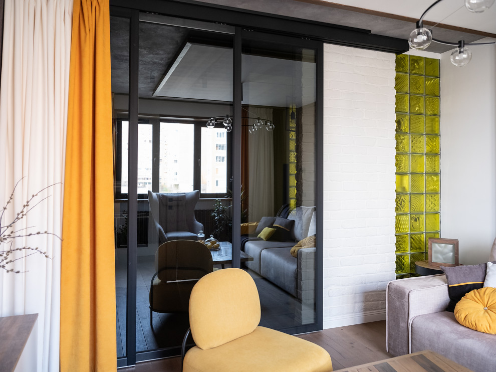 Esempio di un piccolo soggiorno industriale con pareti bianche, pavimento in legno massello medio, pavimento beige e pareti in mattoni