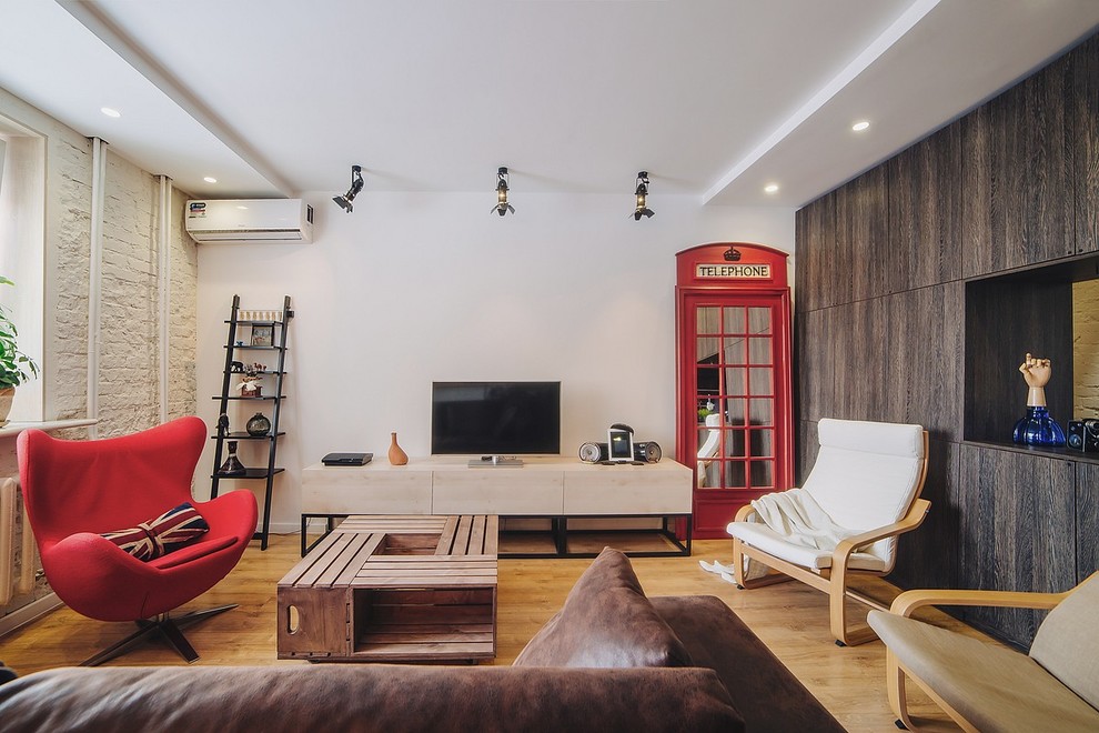 This is an example of an urban games room in Other with white walls, light hardwood flooring and a freestanding tv.