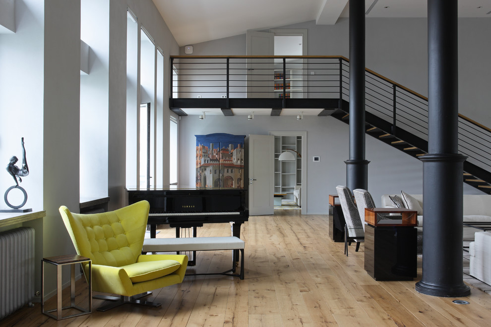 Immagine di un ampio soggiorno contemporaneo aperto con sala della musica, pareti grigie e parquet chiaro