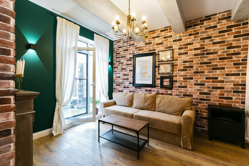 Cette photo montre un petit salon mansardé ou avec mezzanine industriel avec un mur vert, sol en stratifié, une cheminée ribbon, un manteau de cheminée en pierre et un sol marron.