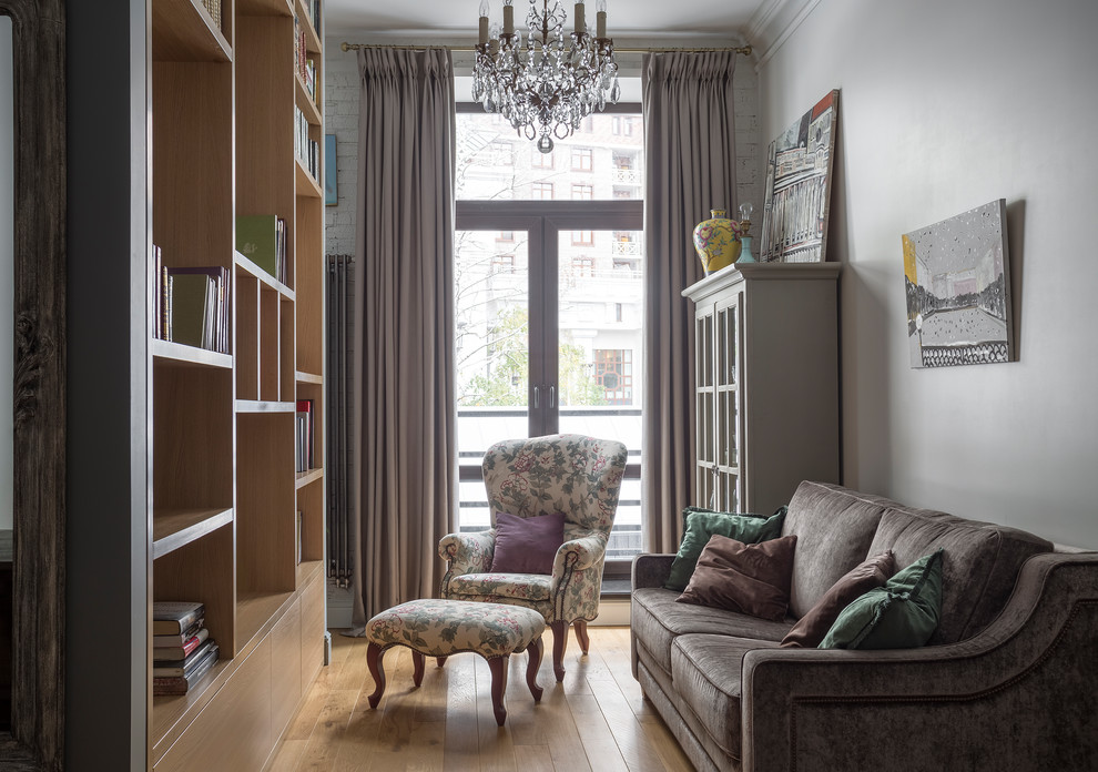 Idee per un piccolo soggiorno chic aperto con libreria, pareti grigie, parquet chiaro e pavimento beige