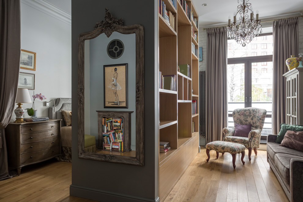 Inspiration pour un petit salon traditionnel ouvert avec une bibliothèque ou un coin lecture, un mur gris, parquet clair et un sol beige.