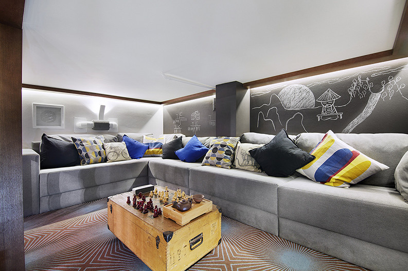 На фото: двухуровневая гостиная комната среднего размера в стиле лофт с с книжными шкафами и полками, серыми стенами и ковровым покрытием без телевизора
