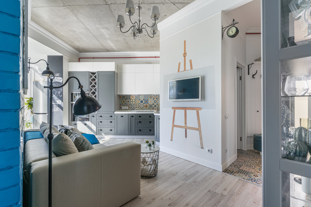 Пример оригинального дизайна: маленькая открытая гостиная комната в современном стиле с полом из ламината, телевизором на стене, серым полом и белыми стенами для на участке и в саду