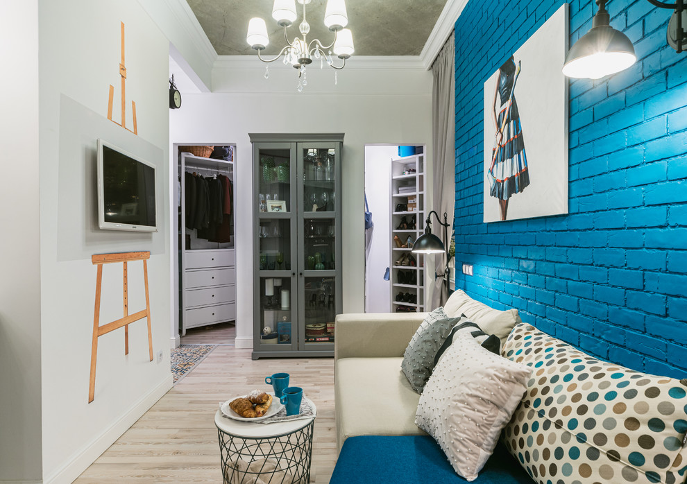 На фото: маленькая открытая гостиная комната в стиле фьюжн с полом из ламината, телевизором на стене и серым полом для на участке и в саду с